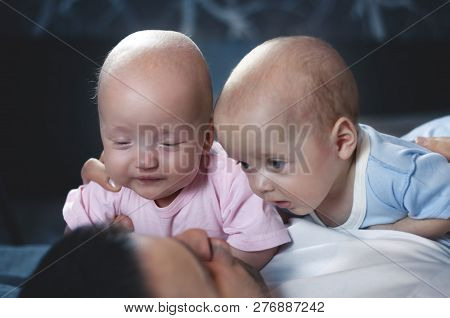 Young Father With His Newborn Twins Lying In Bed. Selective Focus