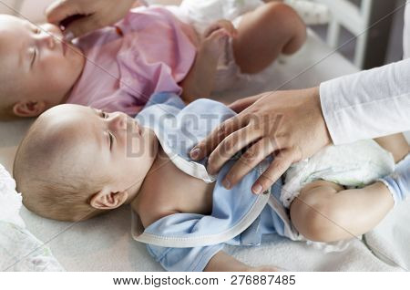 Young Dad Changes The Diaper And Clothes To His Newborn Small Child. Selective Focus