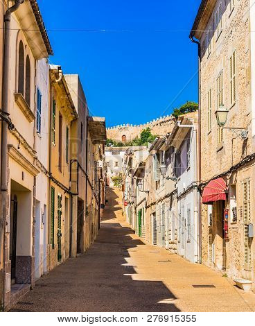 Street View In The Historic Town Of Capdepera With Fortified Wall In The Background, Spain Mallorca 