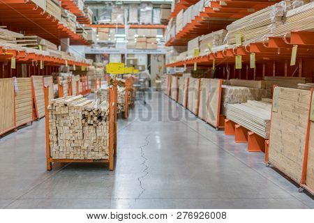 Stack New Wooden Bars On Shelves Inside Lumber Yard Of Large Hardware Store In America. Rack Of Fres