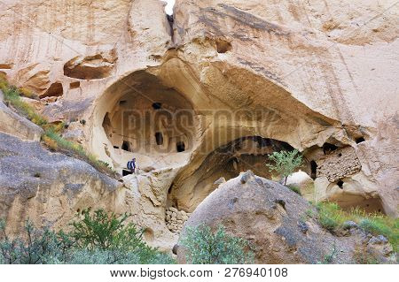 A Young Man, A Tourist, Climbs On The Old Ancient Residential Caves Of Cappadocia, Carved Out Of The