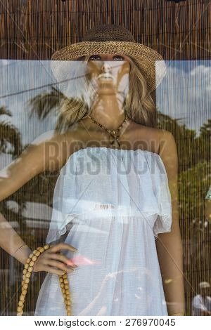 Display And Reflection In Key West Shop Window Of Beautiful Female Manniquin With White Dress And St