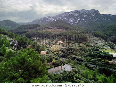 Aerial Drone View Of Small Hillside Banyalbufar Town On West Coast Of Mallorca. Surrounded By Tramun