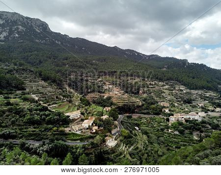 Aerial Drone View Of Small Hillside Banyalbufar Town On West Coast Of Mallorca. Surrounded By Tramun