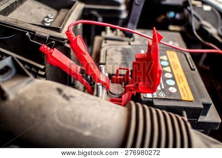Battery Clamps Connected To The Empty Car Accumulator While Charging It Fully With Battery Charger