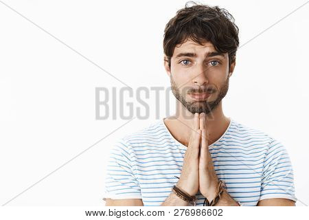 Attractive Hot Boyfriend Making Puppy Eyes And Pouting While Holding Hands In Pray, Asking For Help,