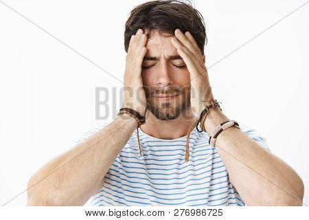 Pressured Uneasy Male Entrepreneur With Beard In Striped T-shirt Having Problems At Work Holding Han
