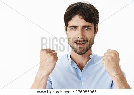Close-up Shot Of Confident And Upbeat Young Creative Handsome Man With Blue Eyes And Beard Raising C