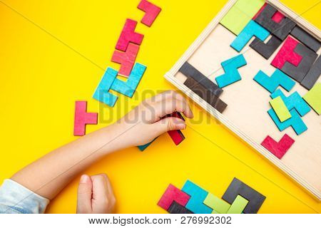 Wooden Puzzle And Kids Hands On Yellow Background. Flat Lay
