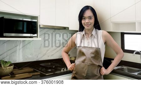 Confedent Asian Woman To Cooking In Kitchen In The House