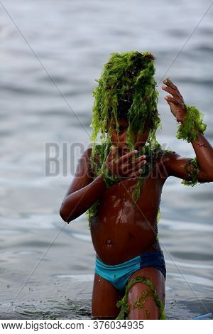 Salvador, Bahia / Brazil - February 2, 2015: Child Plays With Algae On The Rio Vermelho Beach In The