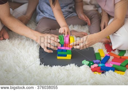Little Girl With Learning Disabilities Or The Group Of Dow Syndrome Is Learning About Colorful Wood 