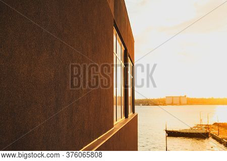 Black Building With Empty Wall Near The River. Amazing Sunset