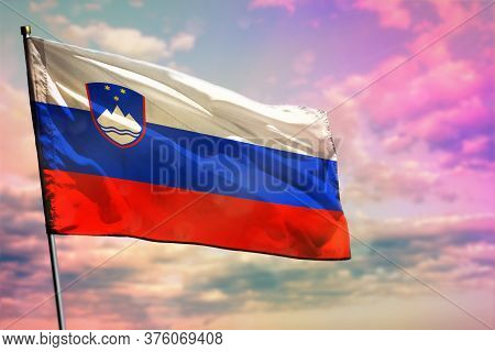 Fluttering Slovenia Flag On Colorful Cloudy Sky Background. Slovenia Prospering Concept.