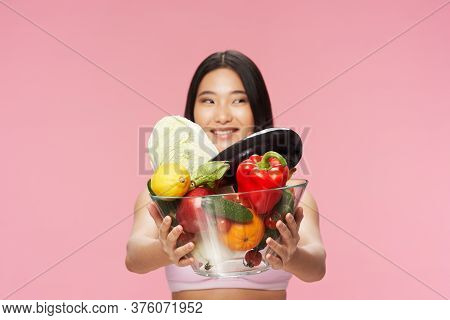 A Woman With Fresh Food In A Plate Smiles