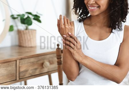 Anti-aging Hand Care. Smiling African Woman Touching Her Soft Body Skin After Beauty Tratment At Hom