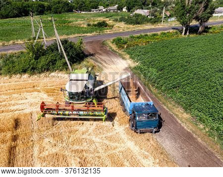 Aerial Drone Top View Big Powerful Industrial Combine Harvester Machine Unloading Bin Of Wheat Cerea