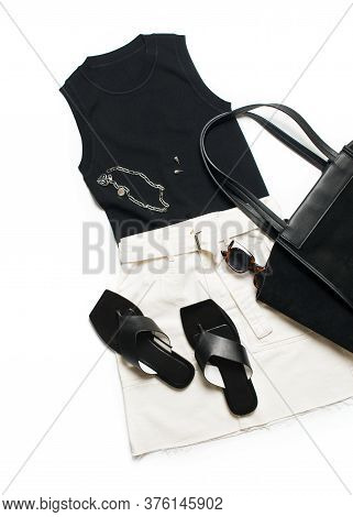 Fashion Set Flat Lay With Blak Top And Flip Flops, Bag And White Skirt And Accessory On White Backgr