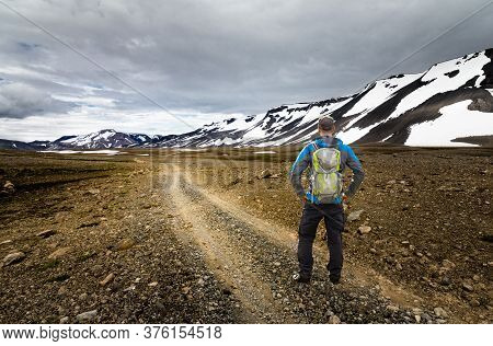 Hiker Man With Backpack Standing On Hiking Trail In Snow Mountain And Arctic Desert. Kaldidalur, Tho