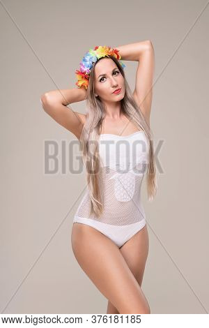 Beautiful Slim And Fit Girl With Long Blond Hair In Whiteswimsuit. Glowing Skin