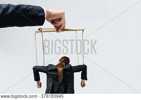 Cropped View Of Puppeteer Holding Businesswoman Marionette On Strings Isolated On Grey