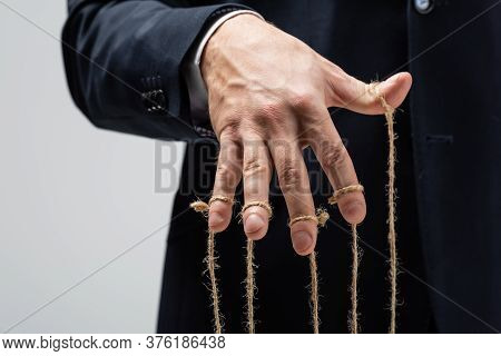 Partial View Of Puppeteer In Suit With Strings On Fingers Isolated On Grey