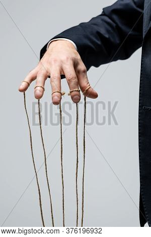 Partial View Of Puppeteer In Suit With Strings On Fingers Isolated On Grey