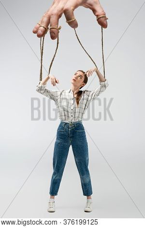 Cropped View Of Puppeteer Holding Marionette On Strings Isolated On Grey