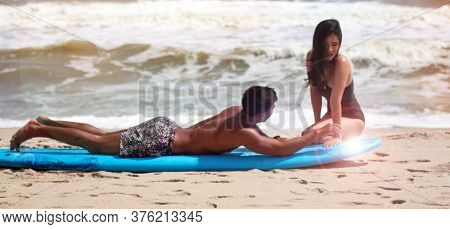 Blur Motion Of Young Handsome Man Teaching Beauty Lady For Basic Patter Of Surfing,on The Beach