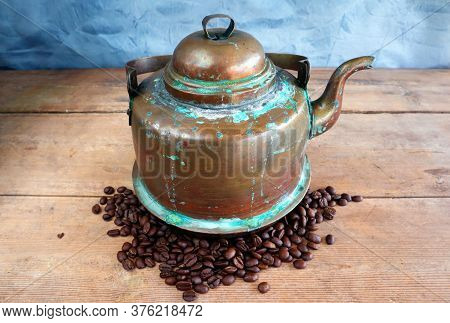 Old Vintage Antique Copper Kettle On A Woodenboard