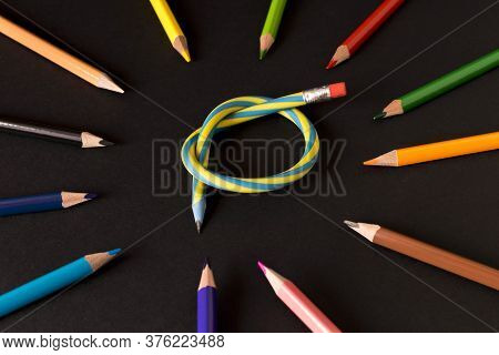 Flexible Pencil And A Set Of Colored Pencils On A Dark Background. Selective Focus