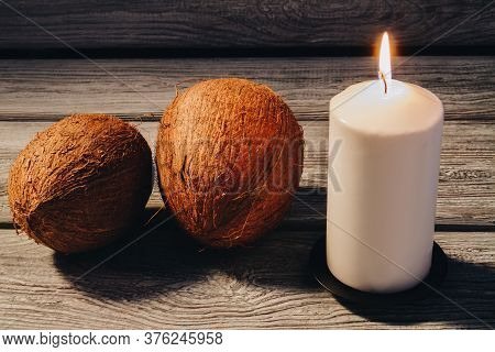 Spa Composition Of Coconuts And Burning Candle On Wooden Background. Spa Relaxtion Therapy.