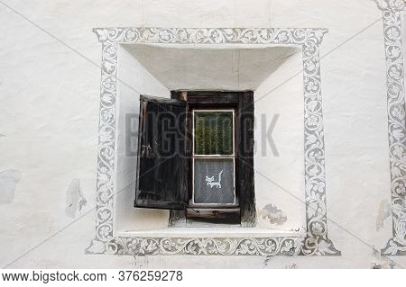 Old Wooden Window On A White Wall With Decorations In The Ancient Village Of Guarda, Scuol Municipal