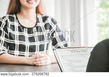 Employer or boss is interviewing for jobs and positions. Woman sitting smiling while submitting a re