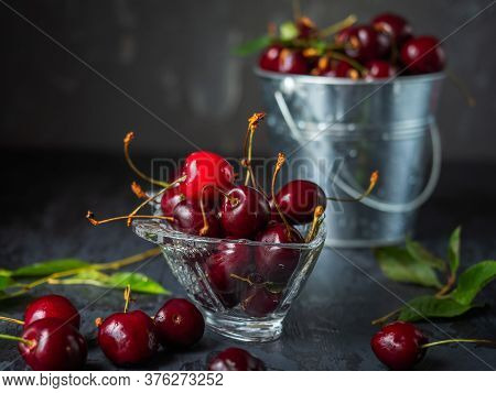 Berry Dessert. Cherry In A Glass Figured Vase And A Metal Bucket Of Cherries