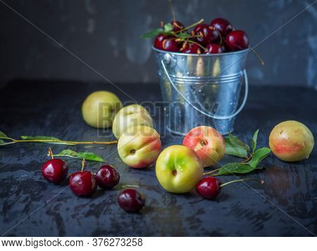 Fruit Set. Ripe Nectaris And Cherries In A Metal Bucket On A Dark Table