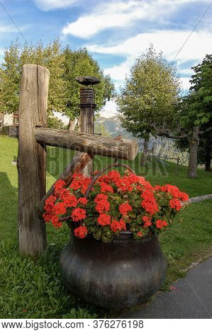 Red Geraniums In A Copper Cauldron In The Ancient Village Of Guarda, Scuol Municipality, Engadin Val