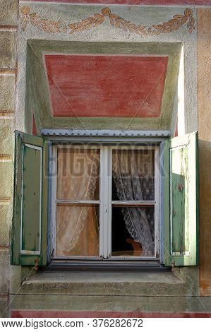 Old Wooden Window On A Wall With Decorations In The Ancient Village Of Guarda, Scuol Municipality, E