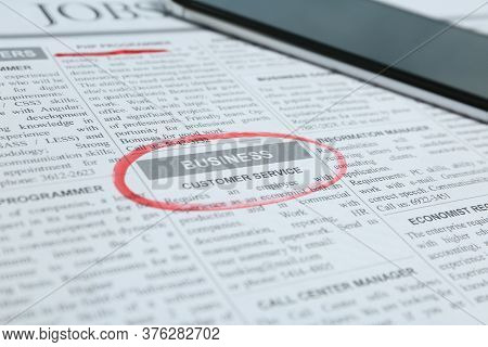 Newspaper With Marked Advertisement And Smartphone. Job Search Concept