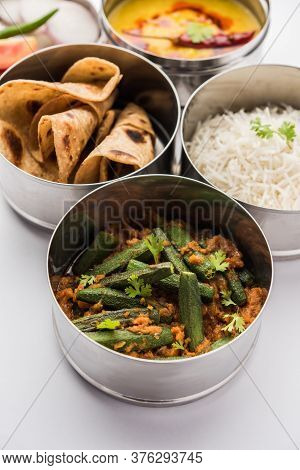 Indian Lunch Box Or Tiffin - Spicy Ladies Finger, Dal Fry, Rice And Chapati