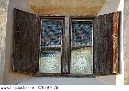 Old Wooden Window With White Curtains In The Ancient Village Of Guarda, Scuol Municipality, Engadin 