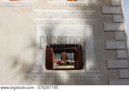 Old Wooden Window With Potted Flowers And Decorations In The Ancient Village Of Ardez, Scuol Municip