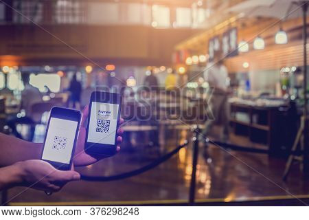 Selective Focus To Smart Phone In Hand To Scan Qr Code On Tag With Blurry Customer Is Buying Food In