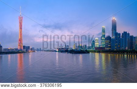Guangzhou, China skyline on the river at dusk.