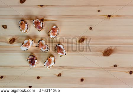Toast With Cream Cheese And Prosciutto. Top View Of Finger Food, Mediterranean Diet. On Wooden Backg