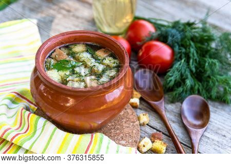 Transparent Broth With Croutons, Dill, Tomatoes On An Old Wooden Background And A Yellow Napkin.