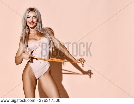 Fitness Perfect Body Weight Loss Concept. Blonde Slim Woman Holds Tape Measure Measuring Waist Smili