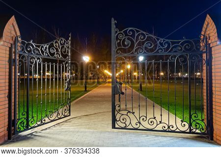The Gates Are Ajar In The Park, In The Evening, The Park Is Lit By Lanterns