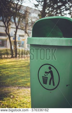 Vertical Shot To A Dumpster Mounted On Pillar With Recycle Symbol On It