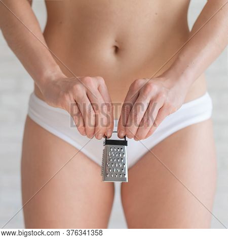Unrecognizable Woman In White Panties Holds In Hands A Mini Grater. Metaphor Of The Bristles After D